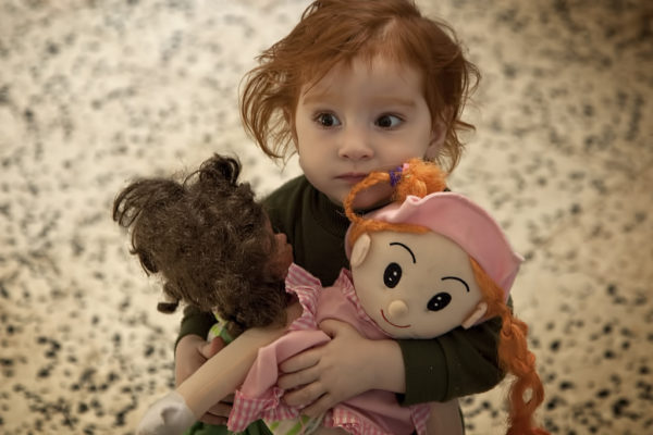 Девочка держит двух больших кукол