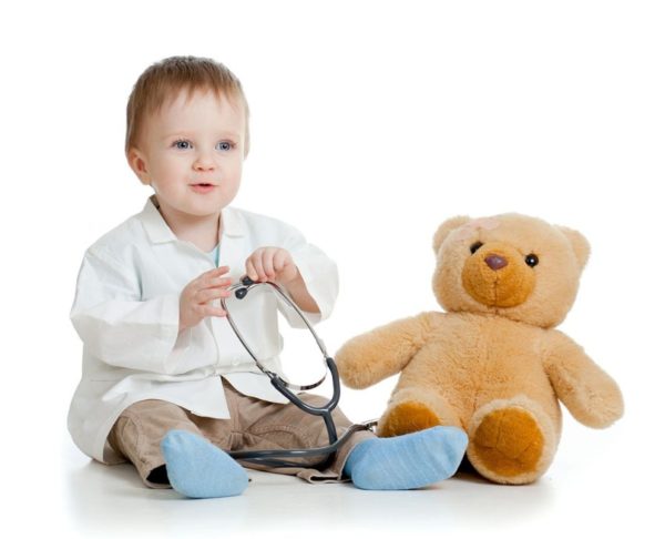 Радостный мальчик со стетоскопом готов лечить плюшевого медведя
