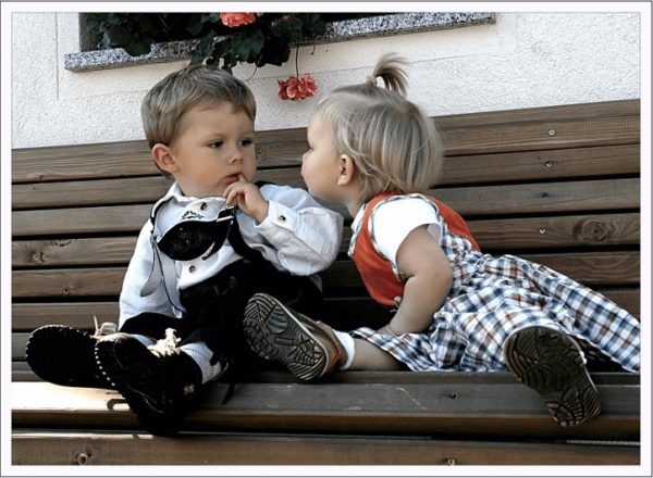 Девочка и мальчик сидят на скамейке
