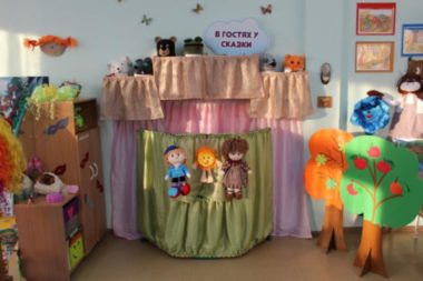 Театральный уголок: ширма, деревья и шкаф с игрушками, стоящий боком