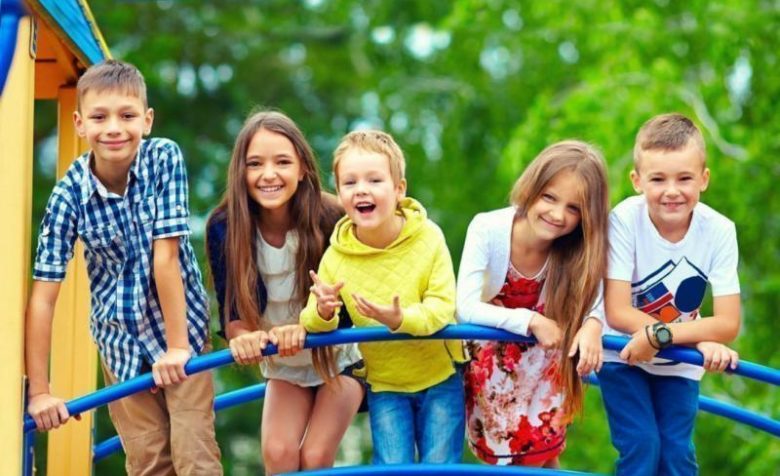 Пятеро детей стоят на мосту на детской площадке