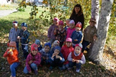Воспитательница с детьми под осенним деревом