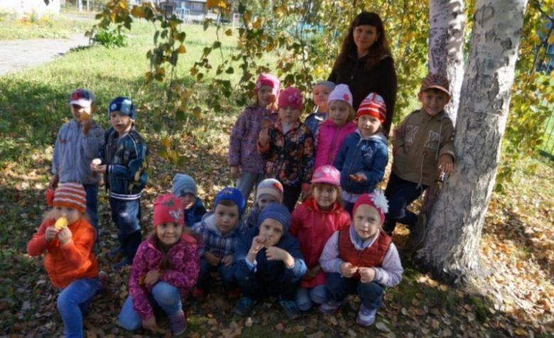 Воспитательница с детьми под осенним деревом