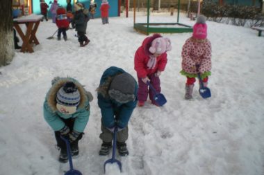 дети расчищают снег