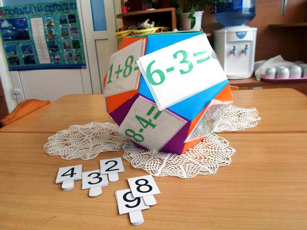 Многоугольник с математическими примерами, на столе лежат карточки с цифрами