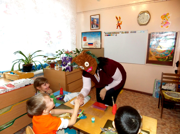 Учитель в маске приветствует детей.