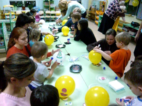 Дети и родители делают человечков из воздушных шариков