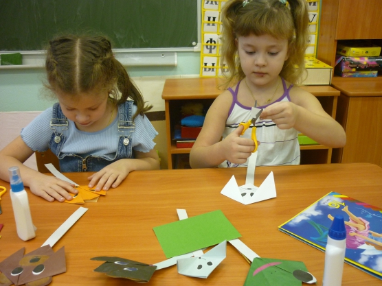 дети делают поделку из бумаги