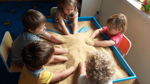 Дети занимаются песочной терапией в группе