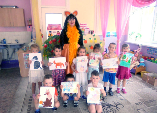 Дети с рисунками в руках и педагог в костюме лисички