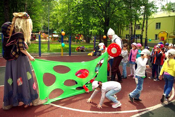 Дети на площадке играют в подвижную игру, организованную сказочными персонажами