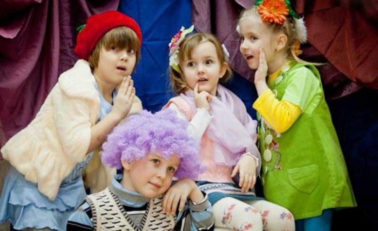 Три девочки и мальчик в сиреневом парике в актёрских образах