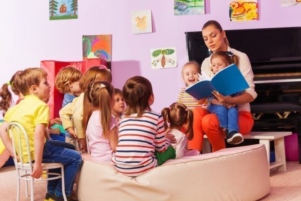 Воспитательница читает детям книгу