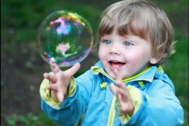 ребёнок рассматривает мыльный пузырь