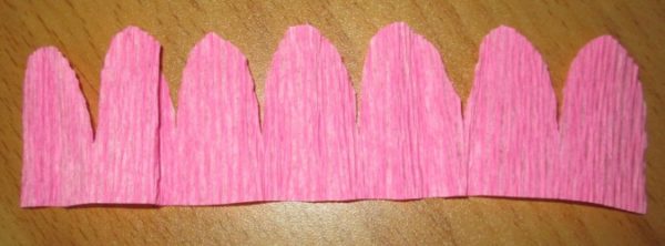 Полоса розовой бумаги с вырезанными зубчиками