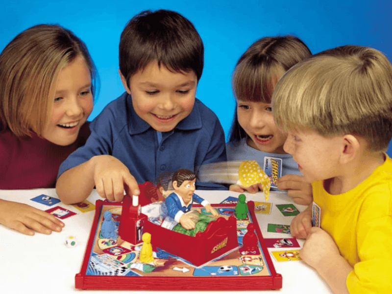 Два мальчика и две девочки играют с игрушкой Человек в спальне
