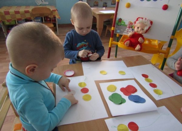 Два мальчика делают аппликацию из кругов цветной бумаги