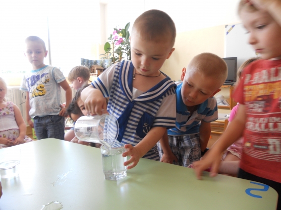 Дети проводят опыт «Имеет ли форму вода?»
