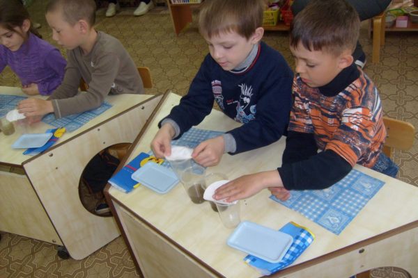 Дети проводят опыт с водой и бумагой