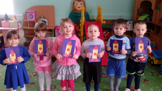 Шестеро детей стоят с аппликациями ракеты в руках