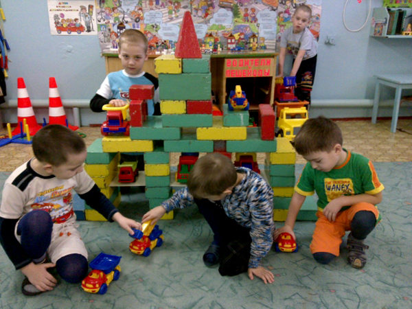 Мальчики построили большой гараж и играют с машинками