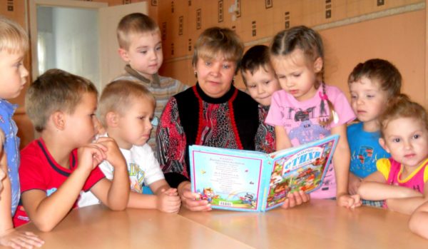 Педагог читает детям книгу