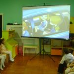 Дети смотрят мультфильм на мультимедийном экране