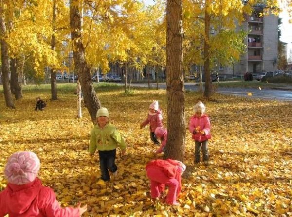 Дети играют в осенней листве