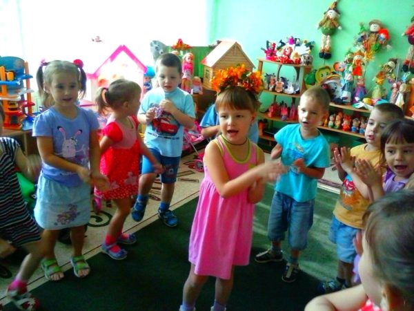 Дети танцуют вокруг девочки с веночком на голове