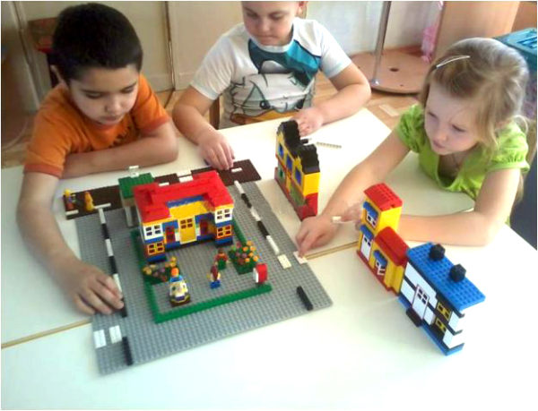 Дети конструируют перекрёсток на большой пластине