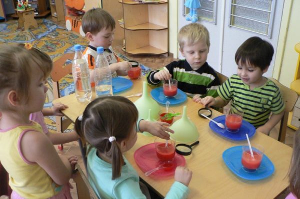 Дети разводят краску в стаканчиках с водой