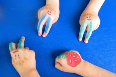Детские руки с нарисованными на них человечками и грибочком