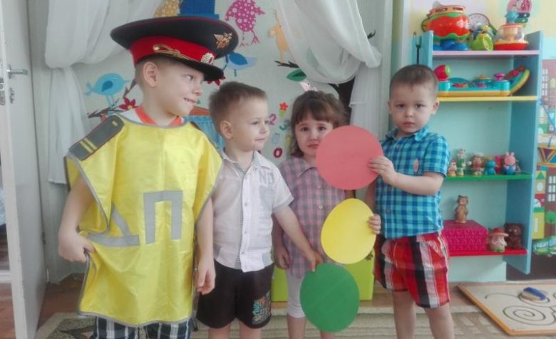 Мальчик в костюме постового и трое детей с цветными кружками светофора