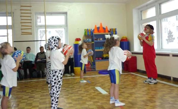 Дети играют в мяч с педагогом в костюме клоуна