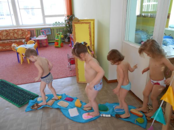 Дети ходят по сенсорным коврикам