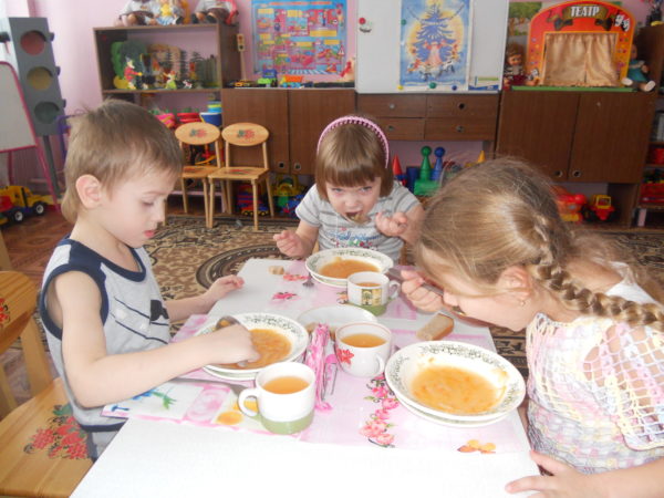 Трое детей обедают