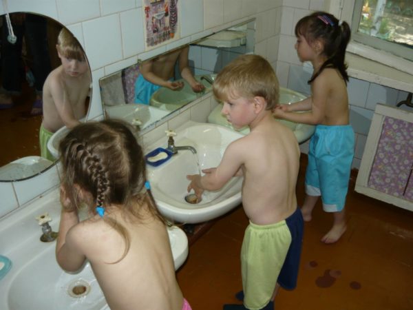 Трое детей моют руки