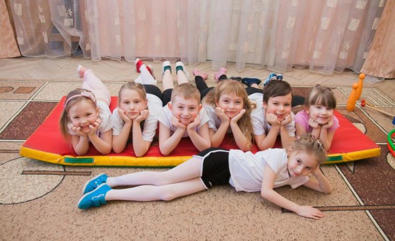 Дети в спортивной форме лежат на полу