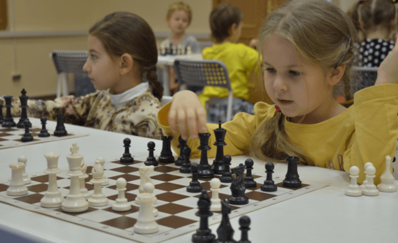 Две девочки сидят за шахматными досками
