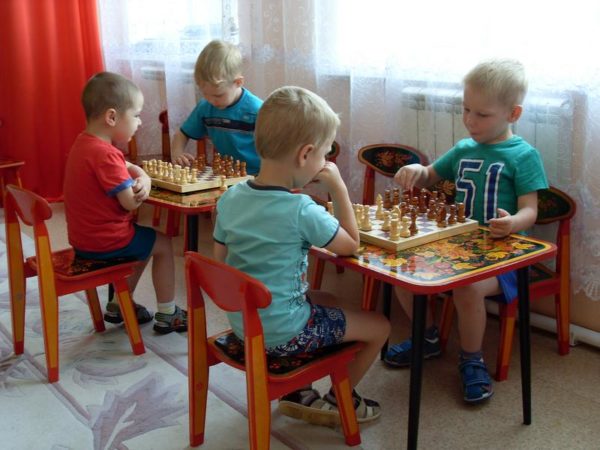 Две пары детей играют в шахматы