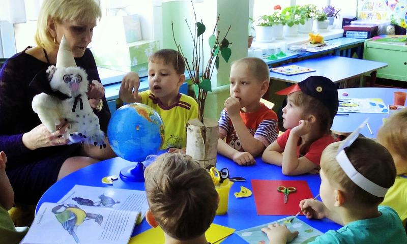 Воспитательница с игрушкой в руках беседует с детьми