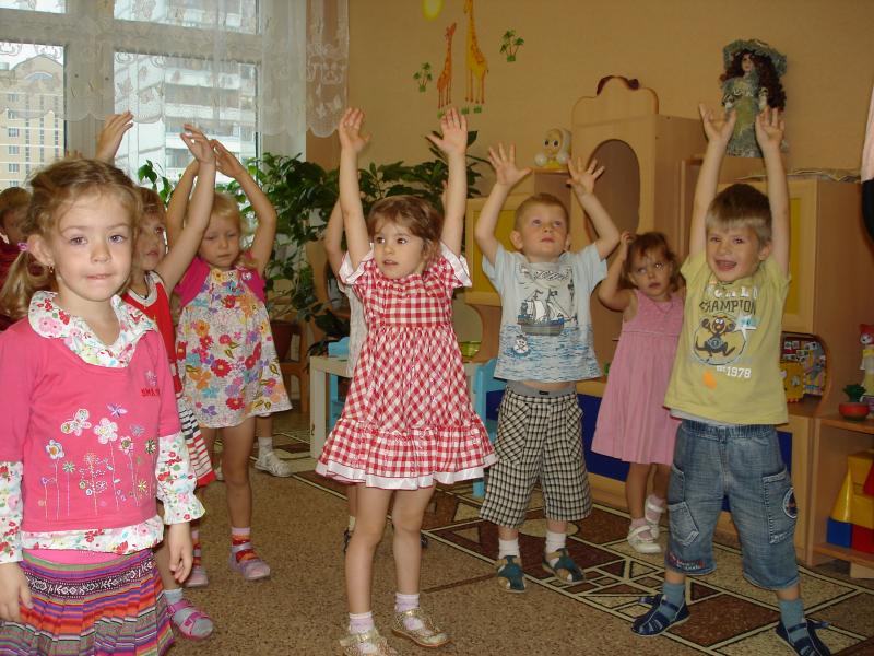 Дети стоят с поднятыми вверх руками