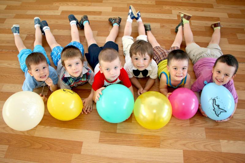 Дети лежат на полу с воздушными шариками