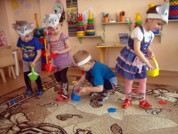 Дети в масках животных собирают игрушечные цветы в корзинки
