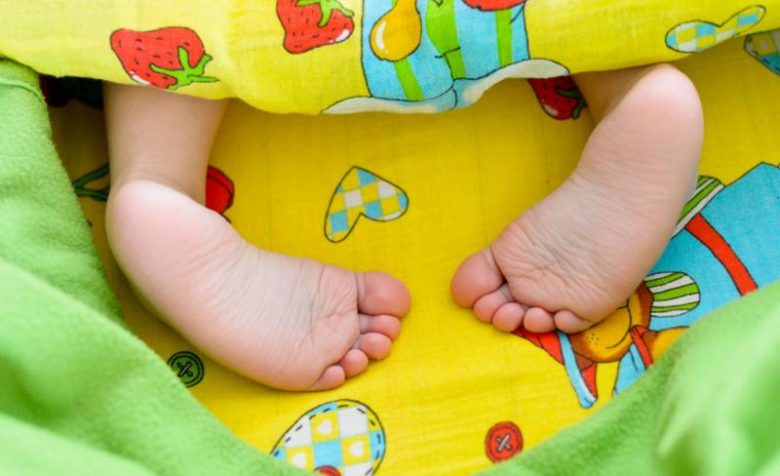 Ножки малыша торчат из-под одеяла