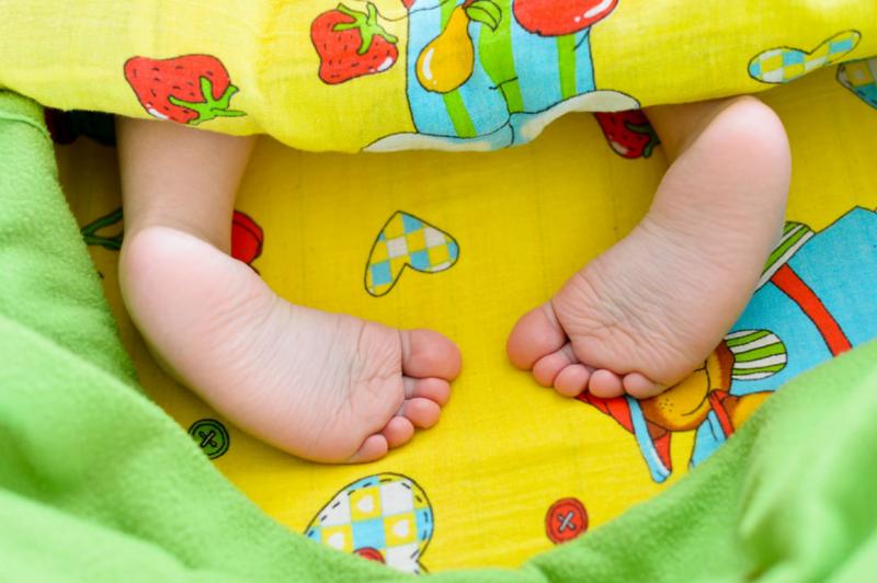 Ножки малыша торчат из-под одеяла