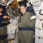 Три космонавта спят в корабле в открытом космосе