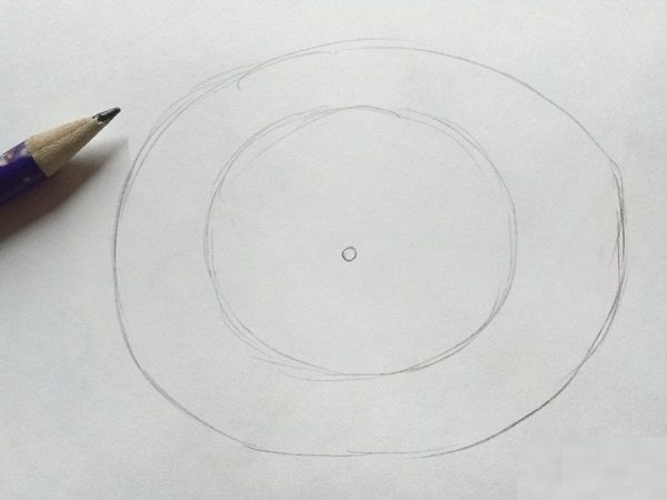 Карандашом намечается маленький кружок в центре, а вокруг него два больших овала