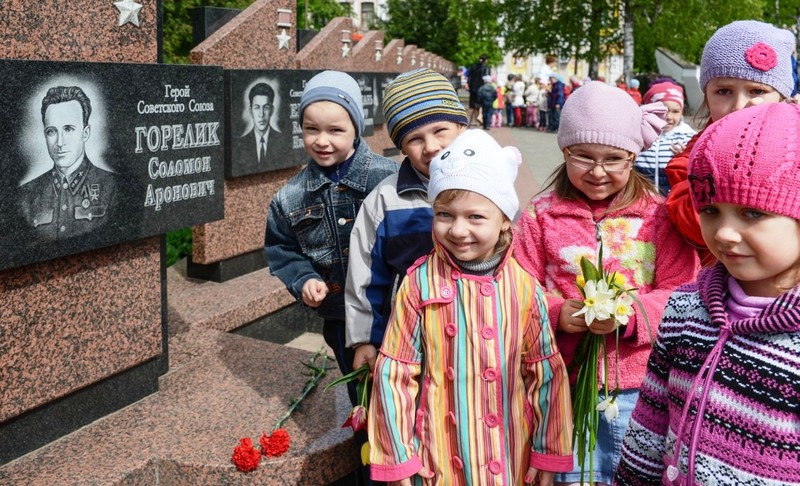 Дети стоят у мемориала героям СССР