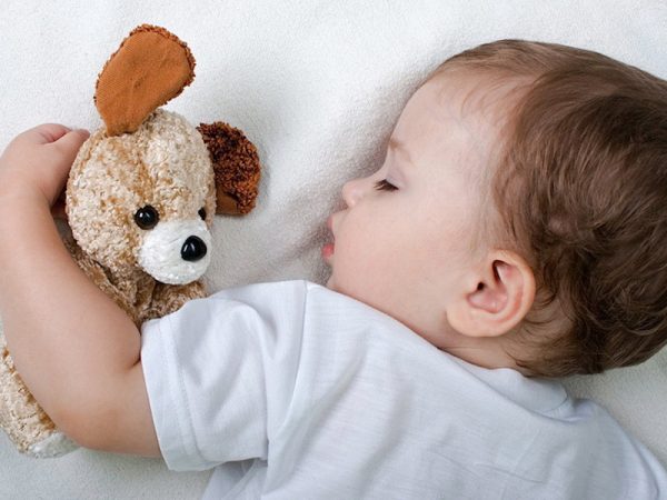 Годовалый мальчик спит с плюшевой игрушкой